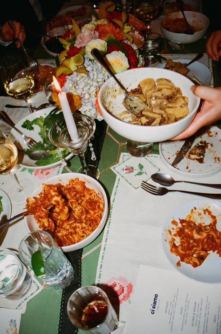 A table after dinner: half-eaten plates and mismatched glasses.